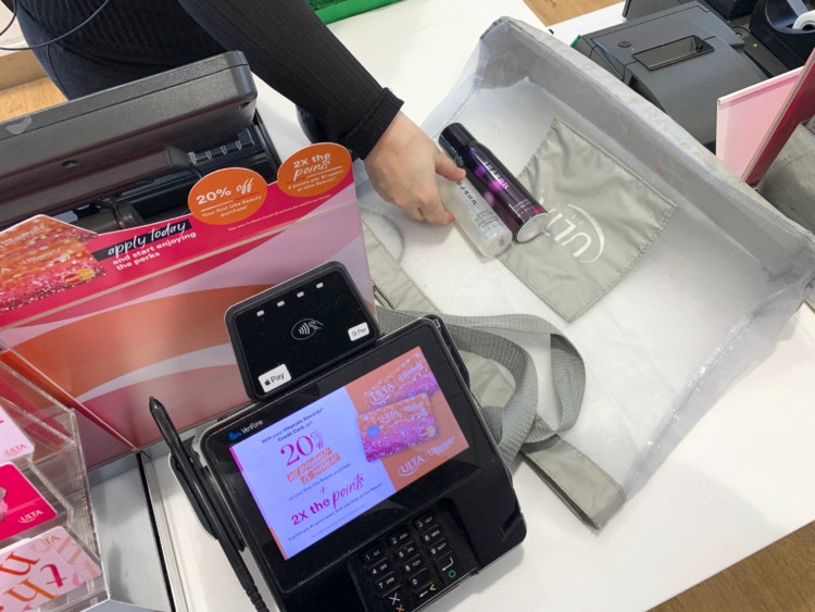 Employee at checkout with hair product and Ulta bag