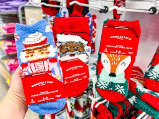 hand holding wondershop cozy socks in front of socks at target
