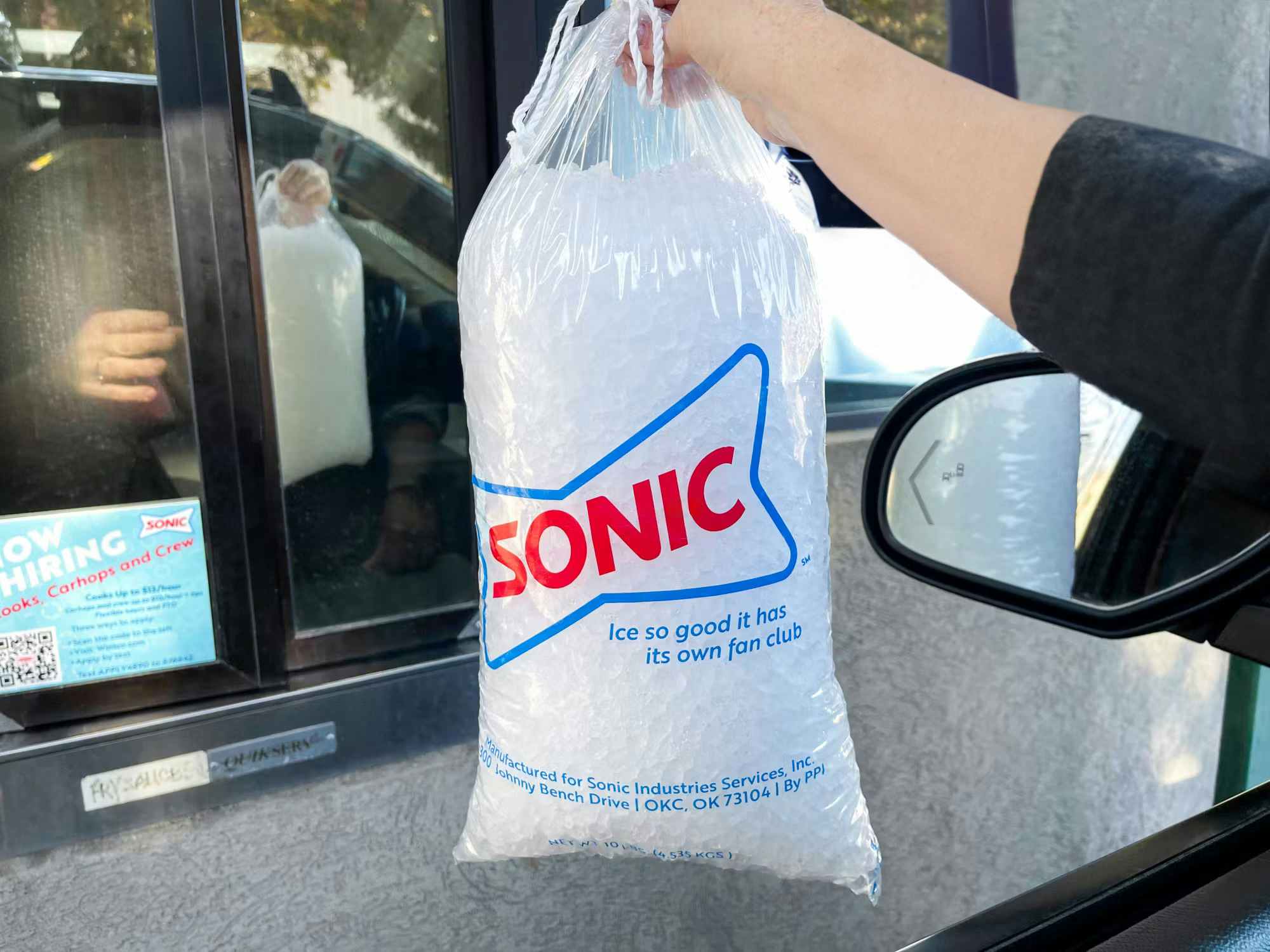 someone getting a bag of ice from a Sonic drive thru