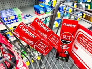 three tubes of optic white toothpaste in a shopping cart