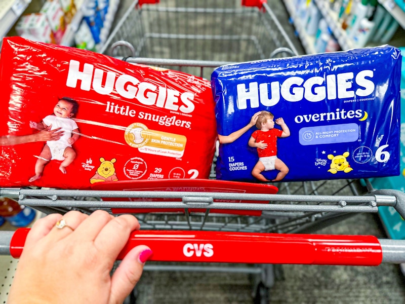 person pushing a cart with huggies diapers in it