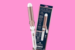 a rose gold and white curling iron next to its packaging 