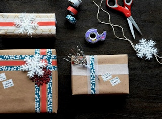 wrapped and decorated gifts next to tape and scissors