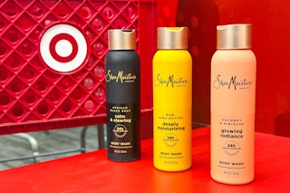3 sheamoisture body wash bottles sitting in front of a target cart
