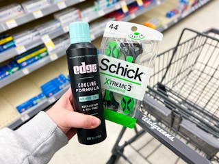 hand holding schick and edge shave care next to a Walgreens shopping cart