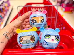 hand holding littlest pet shop plush with two others in target cart