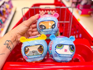 hand holding littlest pet shop plush with two others in target cart
