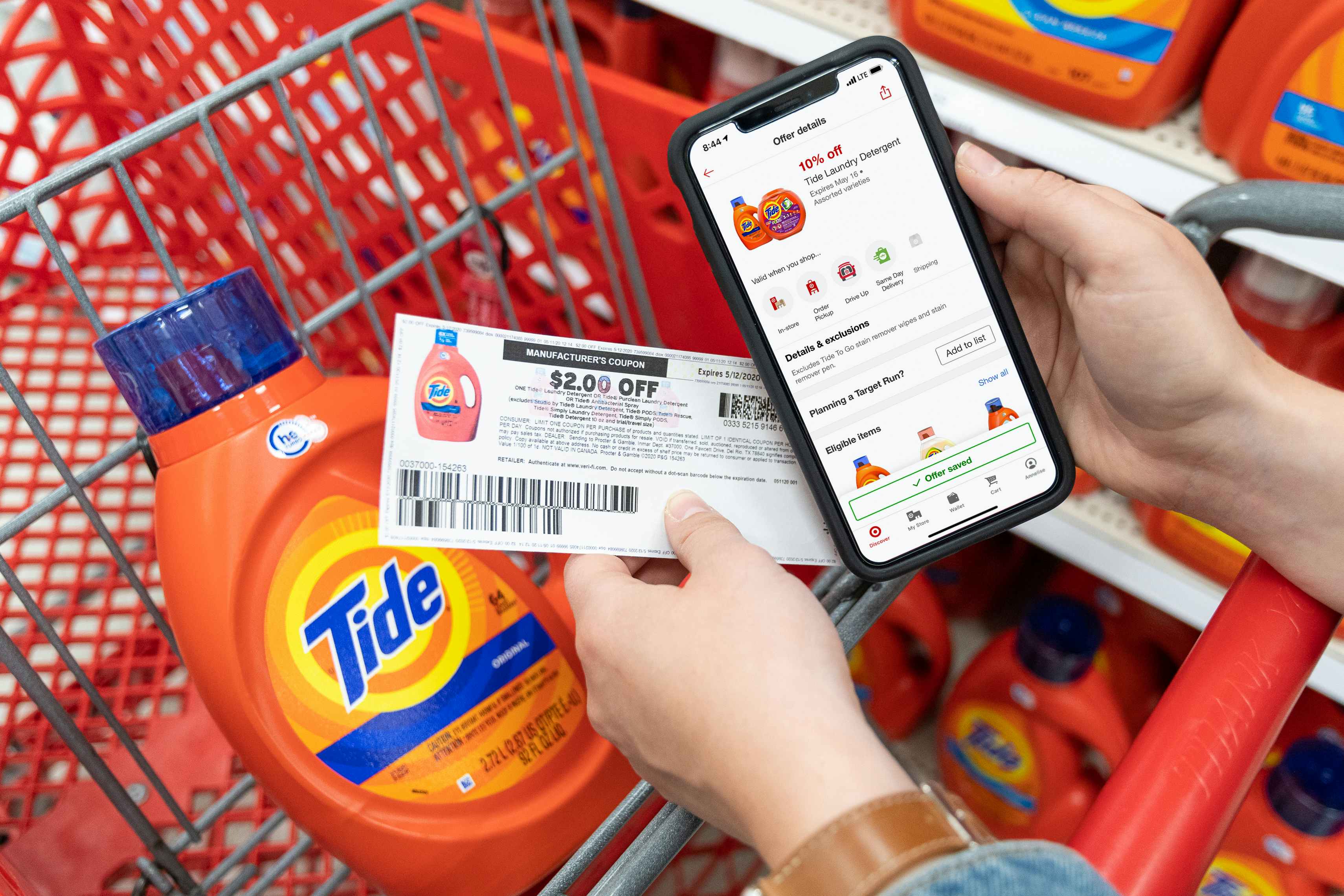 A person's hands holding a cell phone displaying 10% off Tide laundry detergent on the target circle app and a $2 off manufacture ...