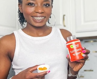 a person taking vitamins from an orange bottle