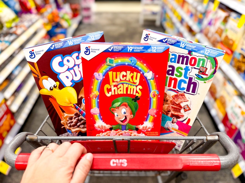 hand pushing a cvs shopping cart with boxes of cereal