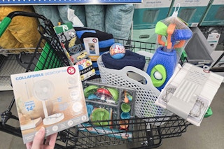 person holding a collapsible desktop fan over a cart full of items at dollar tree