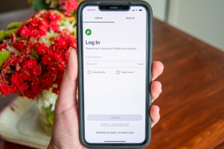 Hand holding a phone showing how to log in to Publix or create an account in the free Publix app.