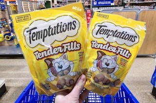 person holding 2 bags of cat treats at petsmart