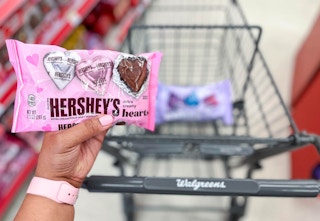 hand holding bag of Hershey's Valentine chocolates in front of shopping cart
