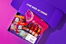 An overhead shot of the Taco Bell "Live Mas at Home" SOS Kit, featuring the boxes of shells, bottles of sauce, seasoning packets, and more.