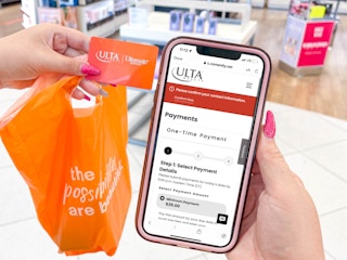 a woman holding a ulta bag and ulta credit card and a cellphone with app to make a payment