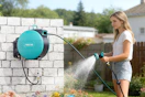 woman spraying yard with garden hose