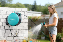 woman spraying yard with garden hose