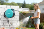 woman spraying yard with garden hose