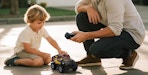 a father and son playing with a remote control car