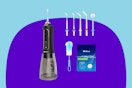 A black water dental flosser with a clear water tank has five extra tips, a cleaning brush, and cleaning tablets.