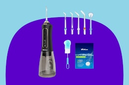 A black water dental flosser with a clear water tank has five extra tips, a cleaning brush, and cleaning tablets.