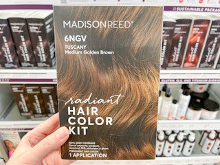Woman holding Madison Reed Hair Color Kit box.
