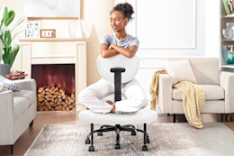 Lifestyle image of the coolhut cross-leg office chair with woman using it 