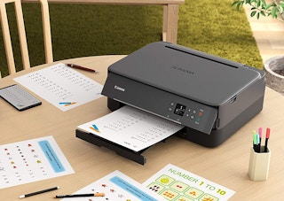 printer surrounded by paper