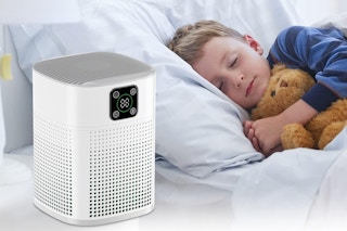 a boy sleeping next to an air purifier