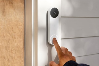 A hand rings a Google Nest Doorbell beside a front door.