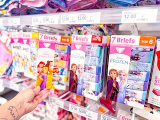 hand holding a disney kids' underwear pack in front of a target shelf
