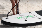 person putting air into paddle board