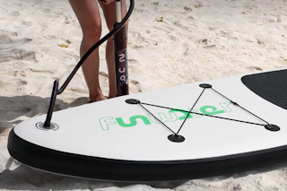 person putting air into paddle board