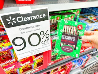 hand holding hershey candy canes in walmart aisle