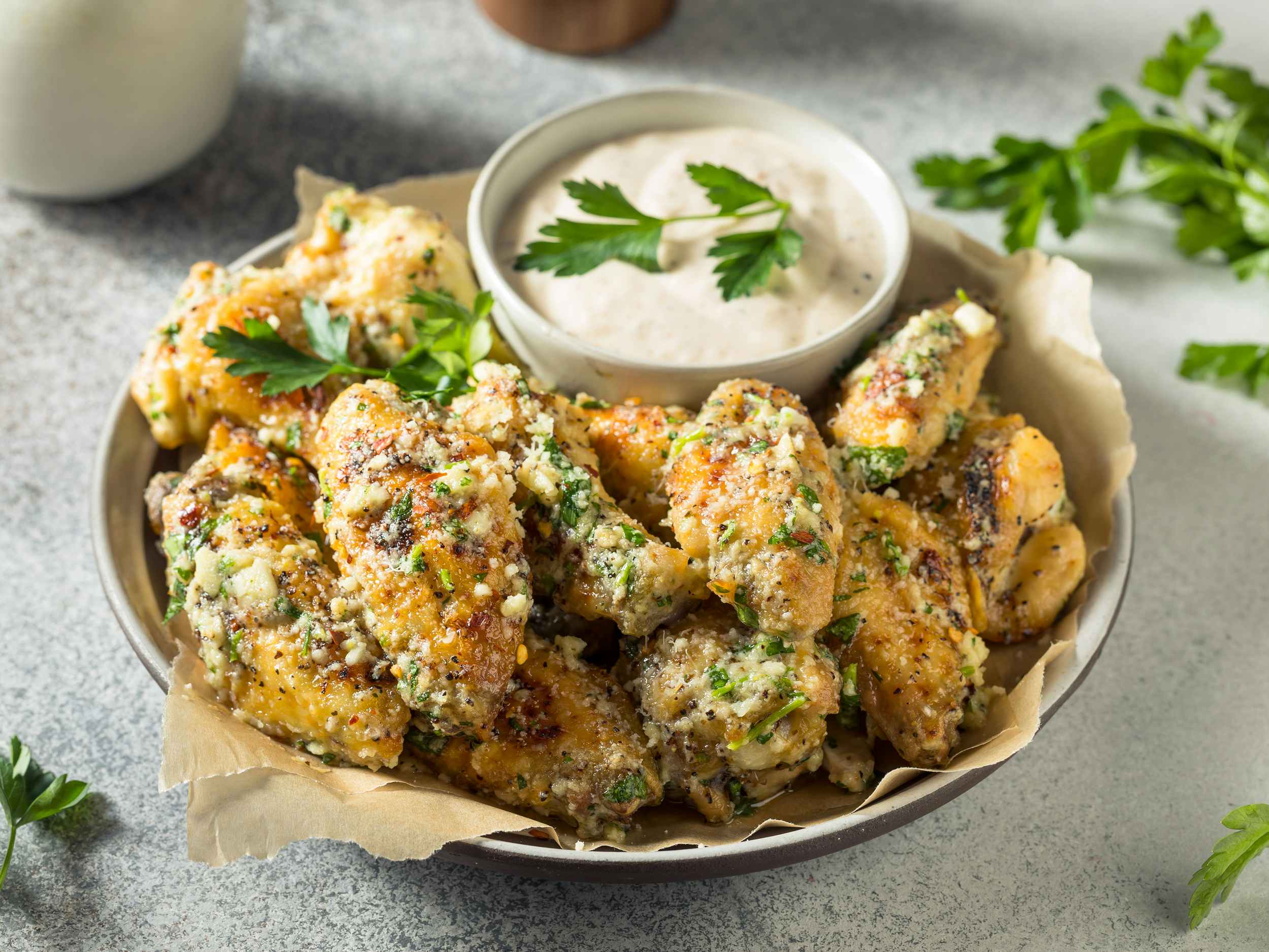 garlic parmesan chicken wings with dipping sauce on plate