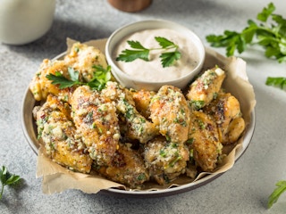 garlic parmesan chicken wings with dipping sauce on plate