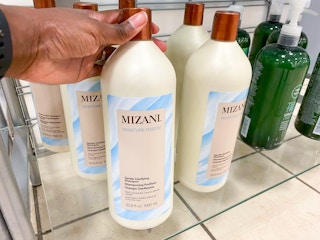 hand holding jumbo shampoo bottle