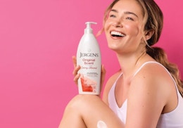 a person holding a bottle of lotion 