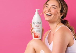 a person holding a bottle of lotion