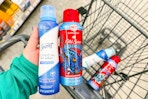 person holding secret and old spice spray deodorants over a cart