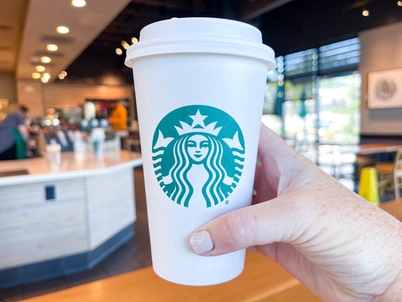 a person holding a starbucks cup in starbucks