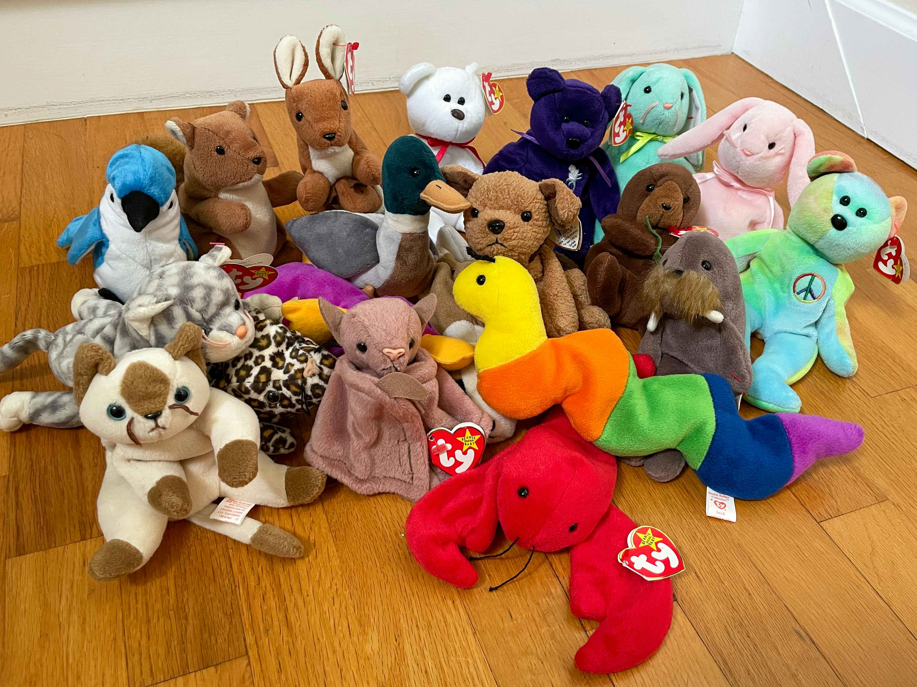 A large pile of beanie babies sitting together on the floor.