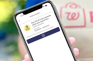 smartphone with Walgreens Cash booster coupon in front of a walgreens pickup bag