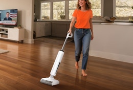a person cleaning hardwood floors with a wet dry vacuum