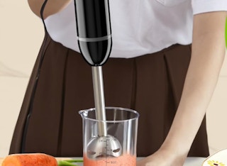 a person blending a smoothie with an immersion blender