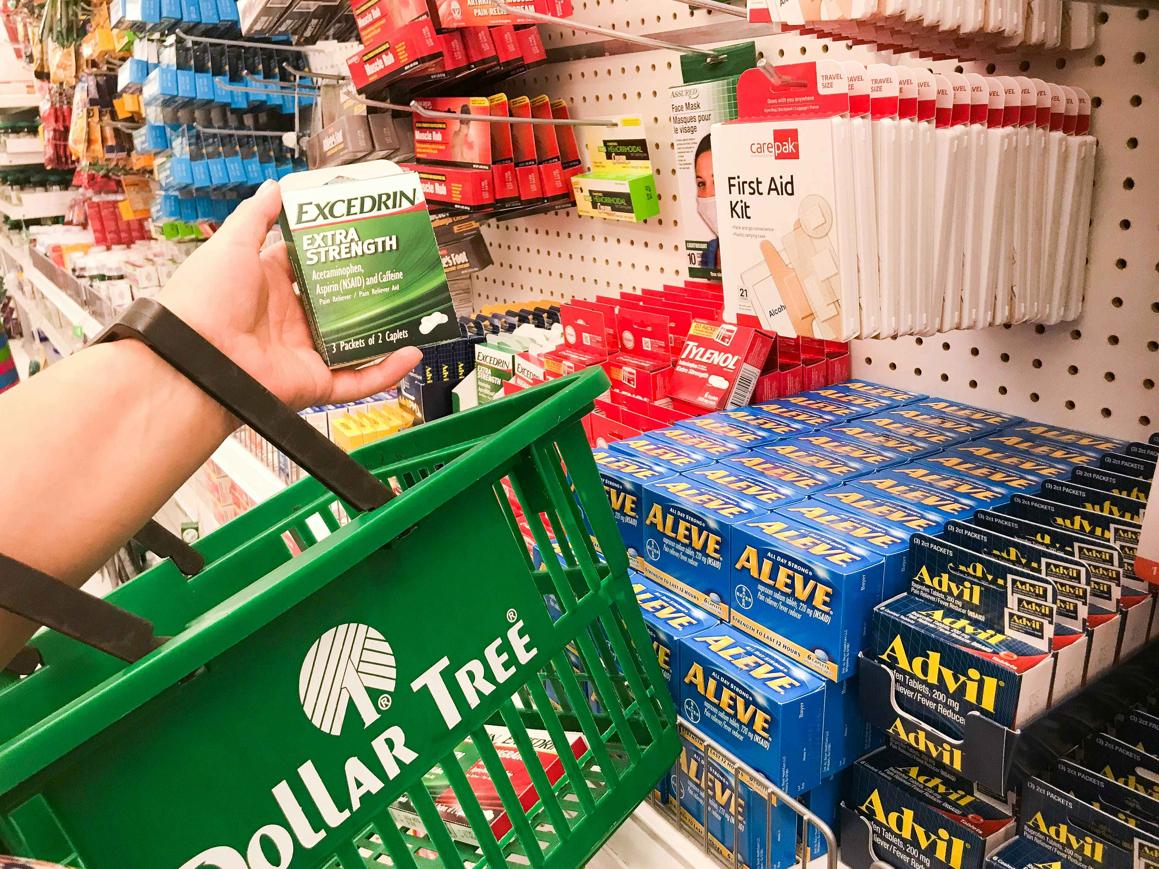 woman shopping at Dollar Tree holding basket and excedrin product