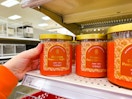 hand grabbing a threshold jar candle off a target shelf