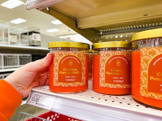 hand grabbing a threshold jar candle off a target shelf