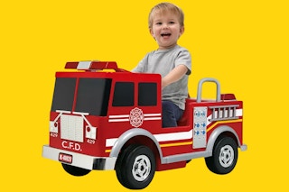 child in a fire truck ride-on toy